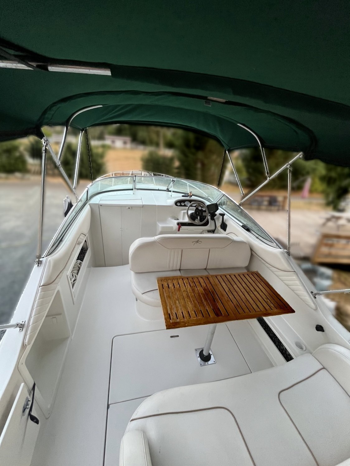 The 2000 / 24FT Monterey 242 features a stylish wooden table, making it perfect for relaxing or entertaining on the water.