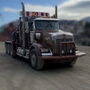 A large brown semi-truck with a red-and-white striped visor is parked on a dirt lot under a partly cloudy sky. The background is blurred.