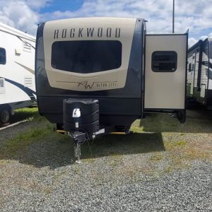 Front view of a 2022 Rockwood Ultra Lite 2906BS travel trailer parked on gravel with its side slide-out extended.